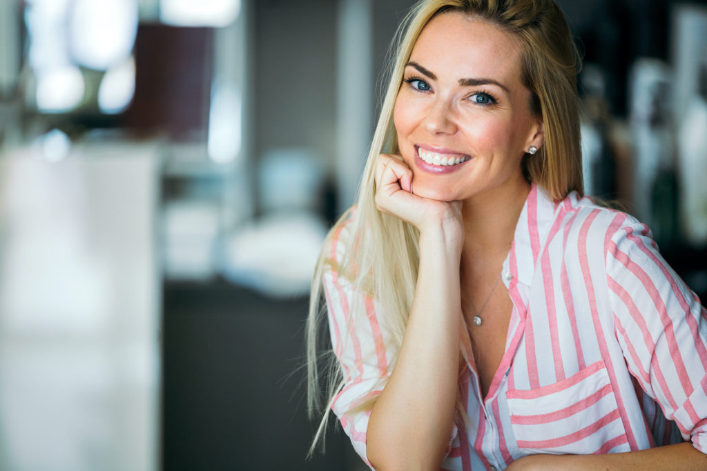 Portrait of beautiful young happy smiling woman with long blond hair